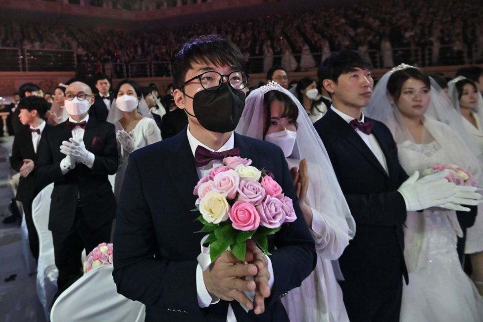 A couple wearing protective face masks attend a mass wedding ceremony organised by the Unification Church in Gapyeong